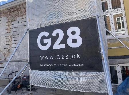 Stort G28 banner monteret på stilladsramme udendørs