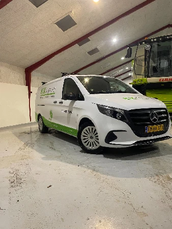 Hvid KKS El firmabil med grøn bildekoration og logo