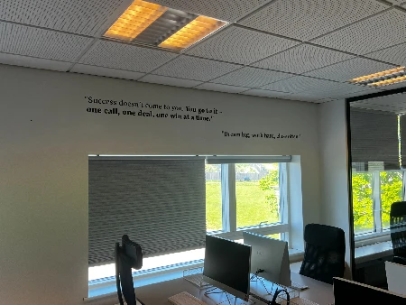 Kontorvæg med printede citater og motivation skåret i folie
