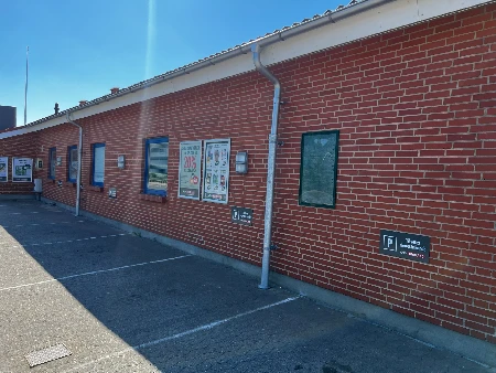 Facade med flere monterede vægskilte på mursten