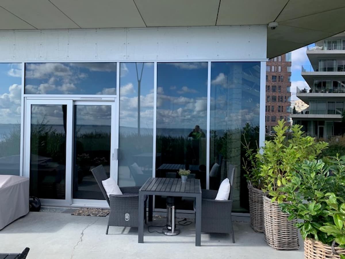 Penthouseterrasse med solfilm på store vinduespartier